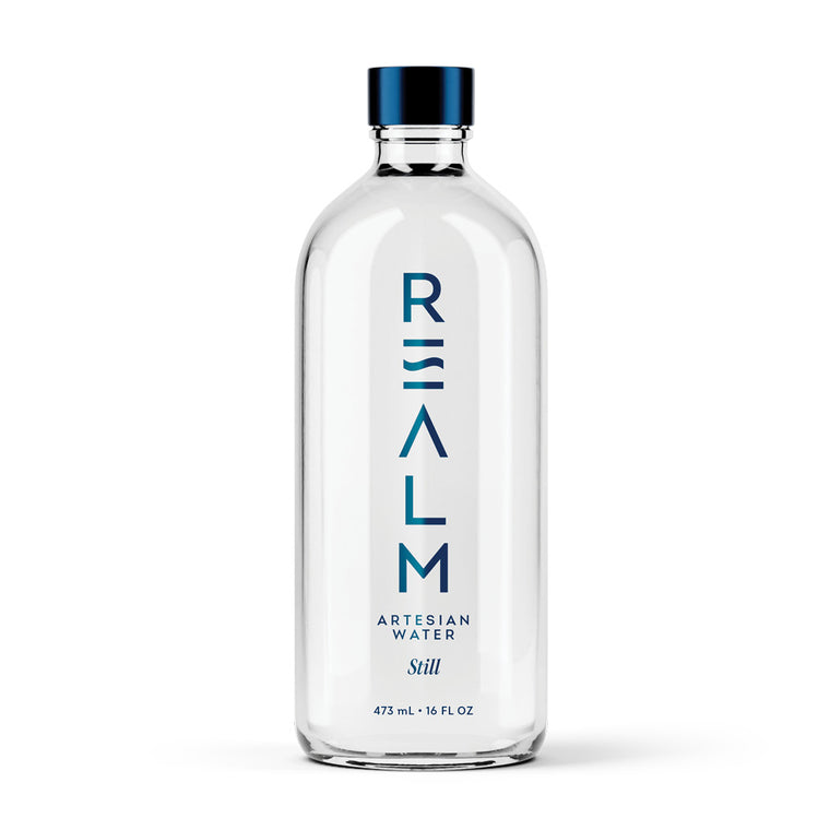 Realm Artesian Water still water glass bottle 473ml 16 fl oz on white background