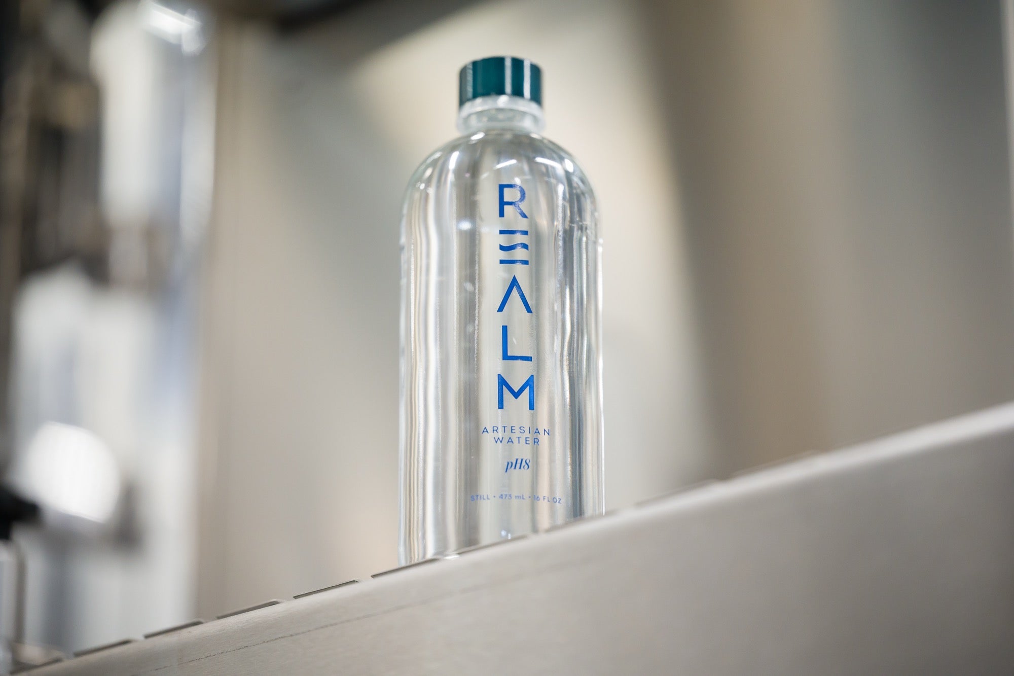 A filled REALM bottle leaving the line